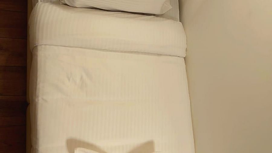 Top view of a bed with pillows and decor on it at Hotel Raai, Hosur.