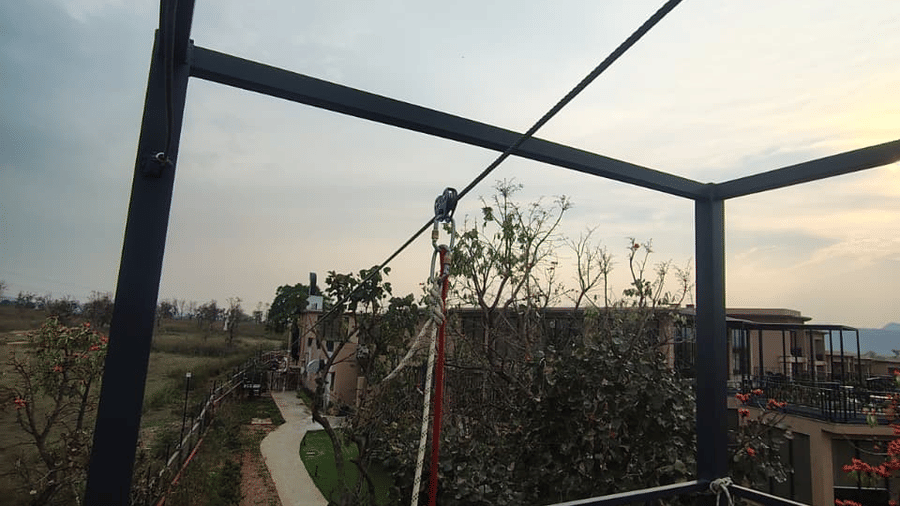 A high-angle view from a metal structure featuring a landscape with trees and a paved path at Hotel Sonar Bangla, Ajodhya Hills.
