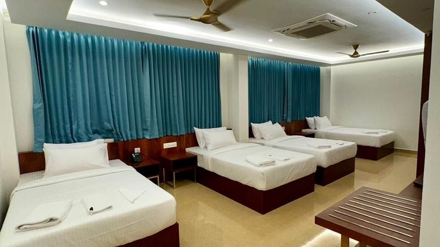 Image of a room with four beds and windows behind the bed at Le Royale Palace.