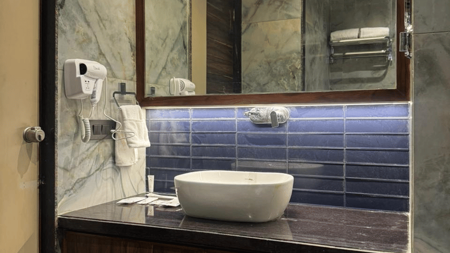 Modern bathroom featuring a vessel sink and back-lit vanity mirror - Lords Swastik Studio, Kodinar