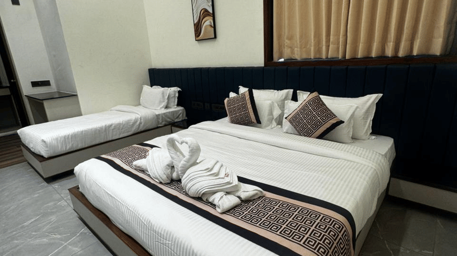Premium double bed and a single bed with decorative runners and towel art - Lords Swastik Studio, Kodinar