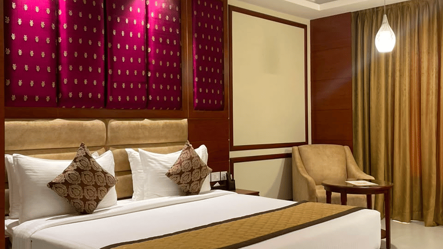 A room with a large bed, sheets, pillows, and curtains. | MM Legacy, Kanchipuram