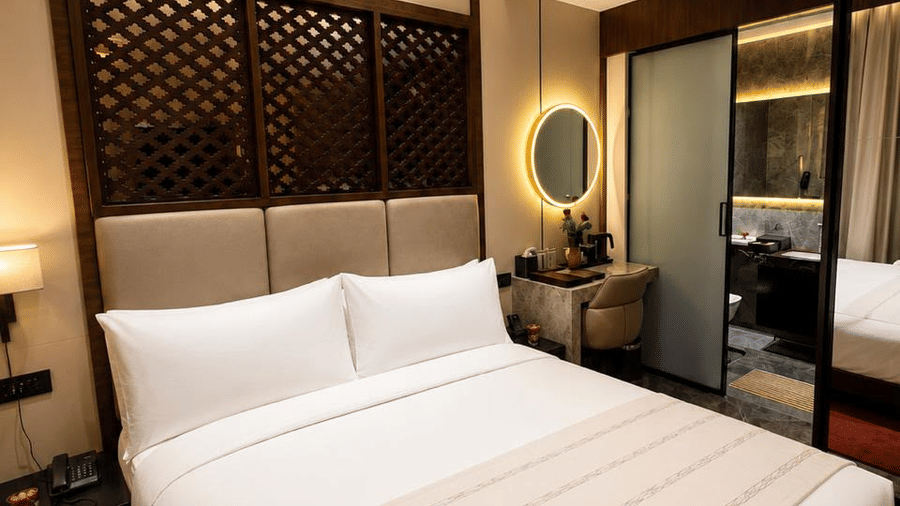 Warmly lit zari room at Ni Central Park with a comfortable king bed and modern smart lighting.