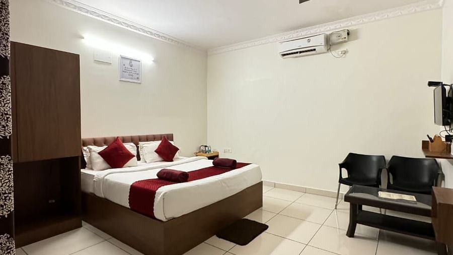A full view of the bedroom with a large bed and wooden furniture | Vistar Resort, Bengaluru