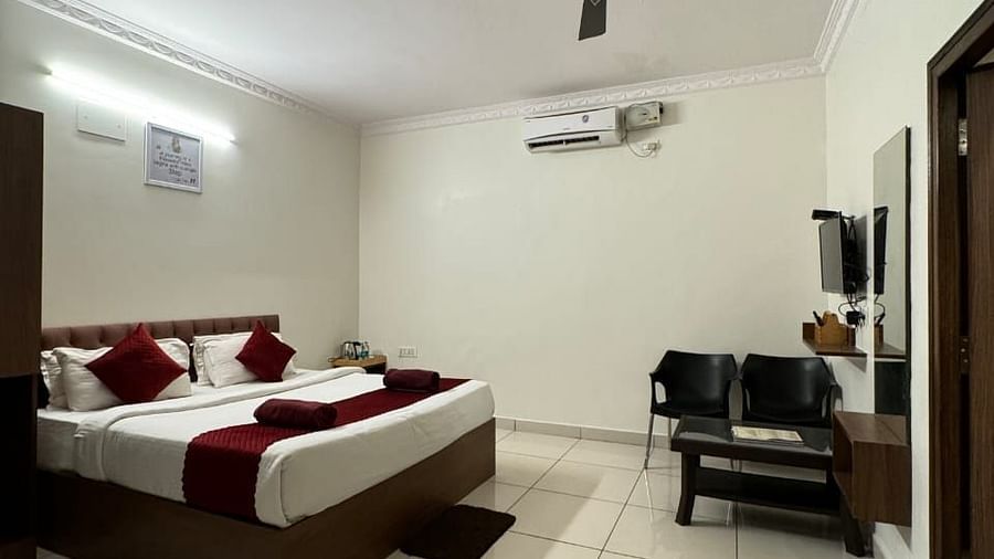 A full view of the bedroom with a large bed and wooden furniture | Vistar Resort, Bengaluru