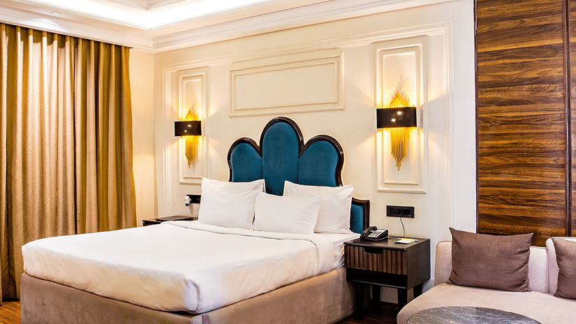 Luxurious hotel room with a king-sized bed and elegant decor with wooden panelled floors - Wedlock Greens Hotel & Resort, Dhanbad