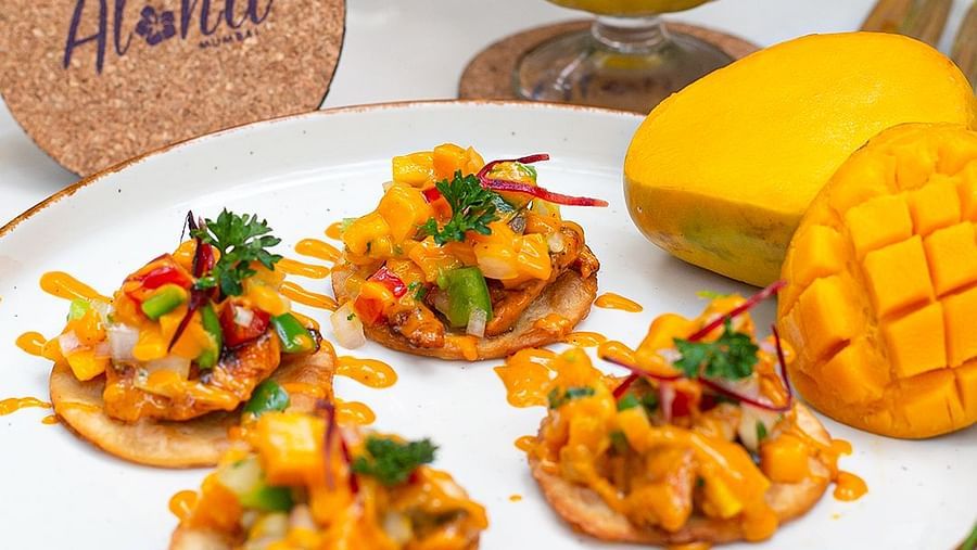 Mango dessert and tropical shrimp dish with an Aloha coaster at Hotel Mumbai House Mindspace, Malad.