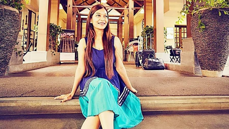 Smiling woman posing at the resort entrance - Rhythm Lonavala