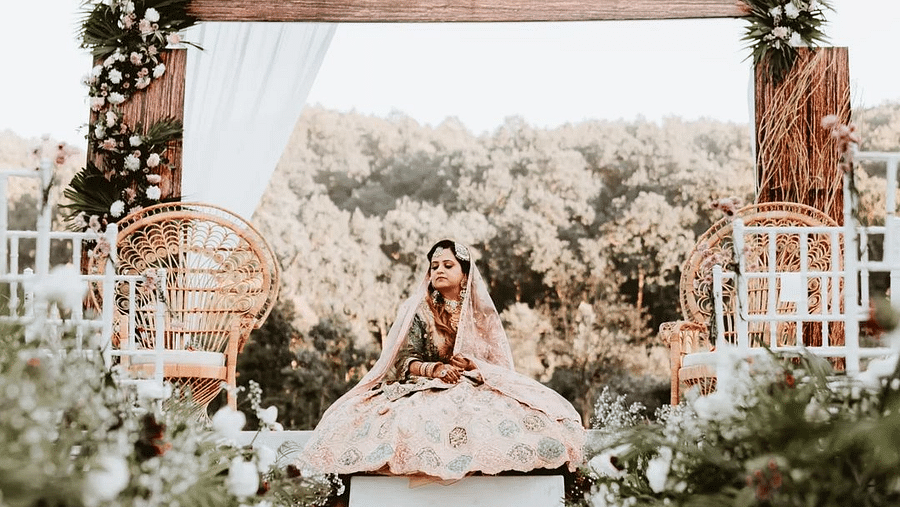 A photo shoot of a bride sitting on a lavish setup of the stage at The Sylvan Retreat, Dehradun.