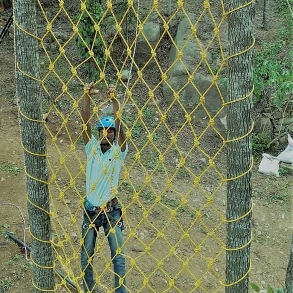 image of a man wearing all the safety gear doing Free Hand Climbing at grand palace yercaud