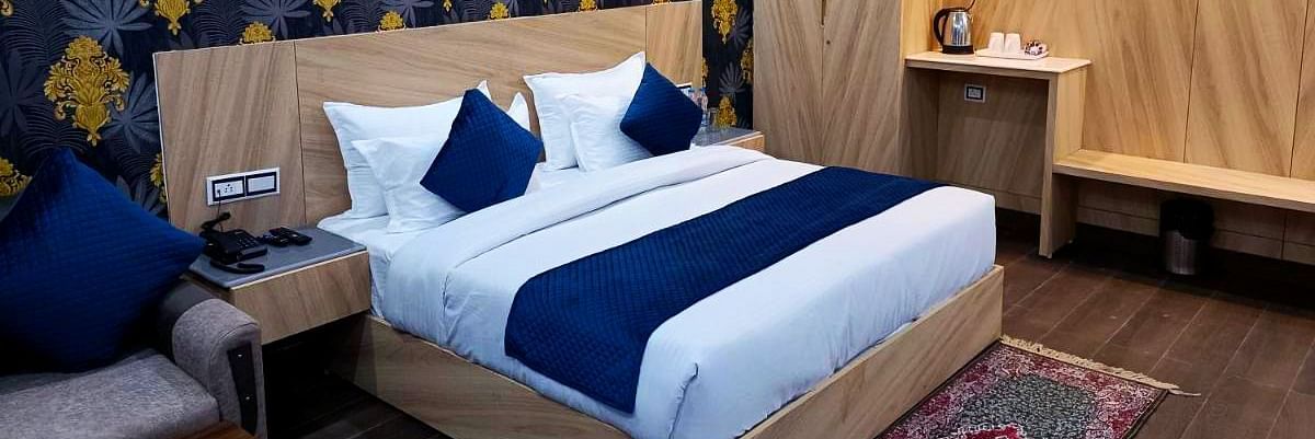 A Deluxe Room at DLS Nature Trinket Resort with a king size bed and a side table.