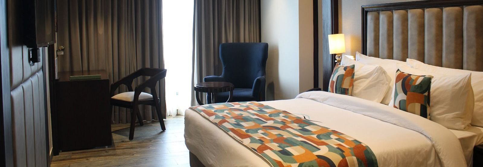 A bedroom with a window draped in curtains at BluSalzz Residence, Amritsar