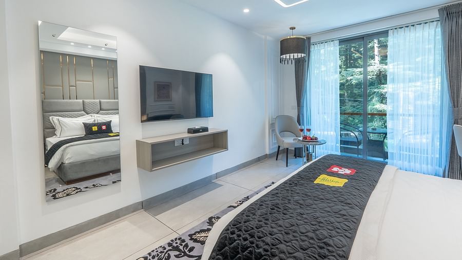 an image of a deluxe room with a mirror and a television at Mastiff Select Mandavya Dharamkot, McLeodganj
