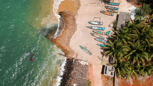 An aerial view of a serene beach with lush greenery
