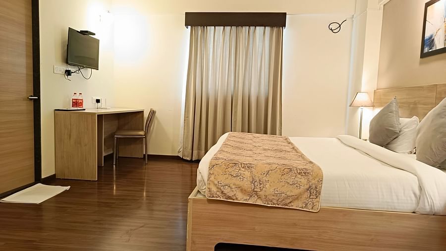 Study table and a TV mounted on the wall above it inside premium studio at Starlit Suites, Shirdi