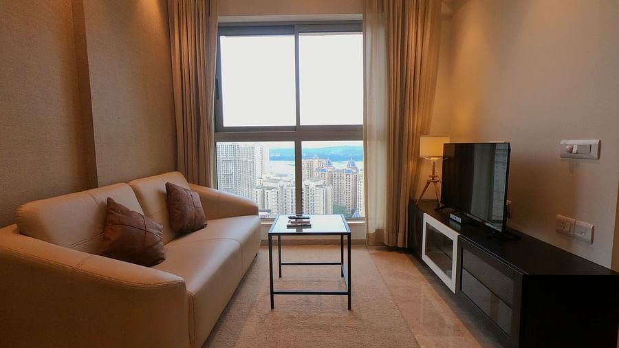 View of illuminated living area with sofa coffee table and TV set - Maxxvalue Apartment, Hiranandani, Powai