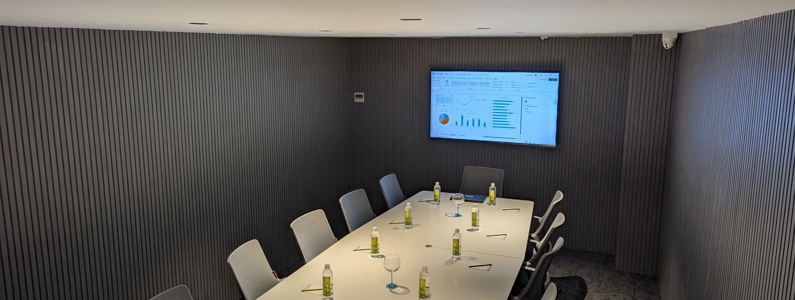 Conference table and presentation screen with grey walls at Fressotel, Kanakapura Road, Bangalore.
