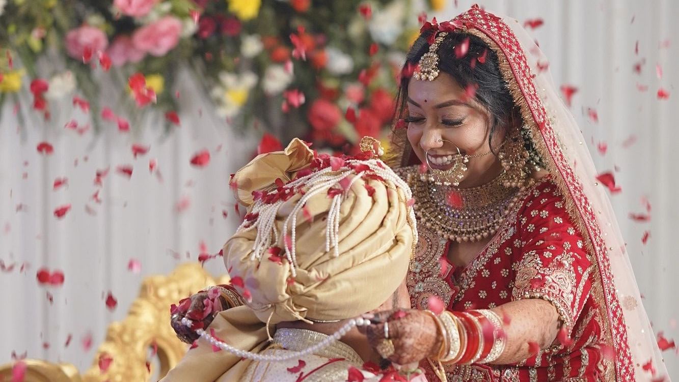 A hindu couple married and the bride is putting garland into the groom's neck at The Zion, Shimla