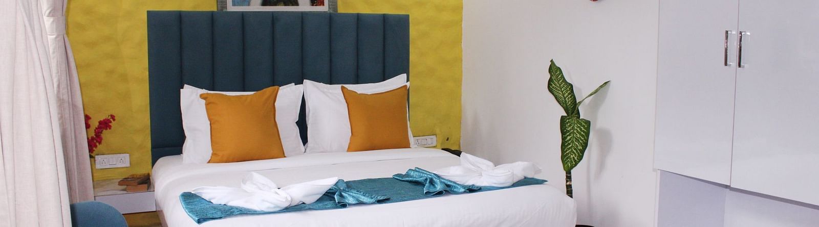 A king size bed with a painting in the background of a Deluxe Cottage Room at Royale Amata - By the Beach.