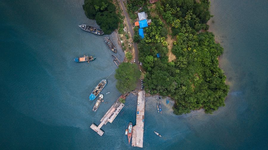 An aerial view of Port Blair with boats, trees and a road in view