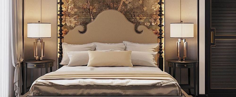 Front view of a well-made bed with cushions, a ceiling fan, and two bedside tables with lamps at The Evren, Vagator.