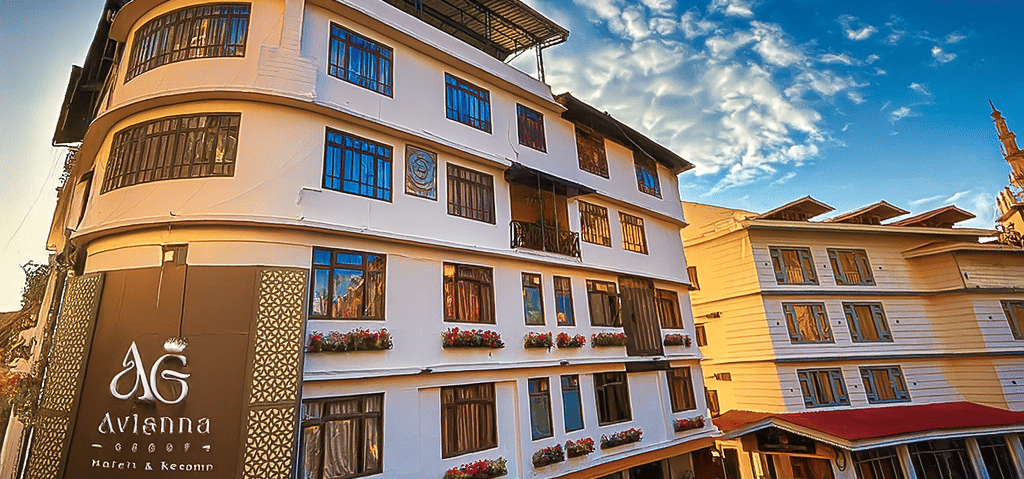 Exterior view of Avianna Group Hungry Jack Hotel in Gangtok with modern white facade, large windows, flower boxes, and clear blue sky