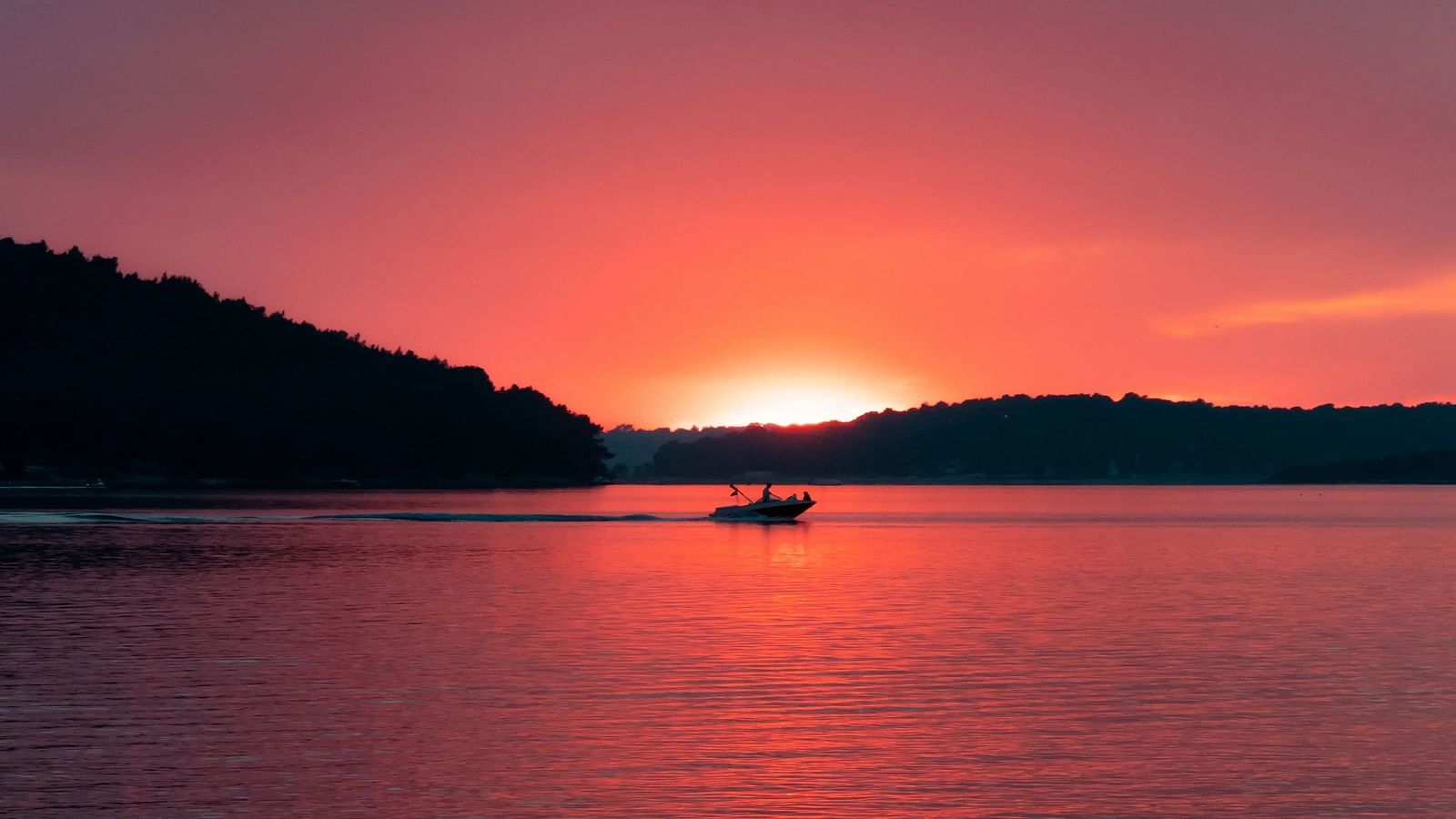 A boat ride during sunset with mountains in the background.
