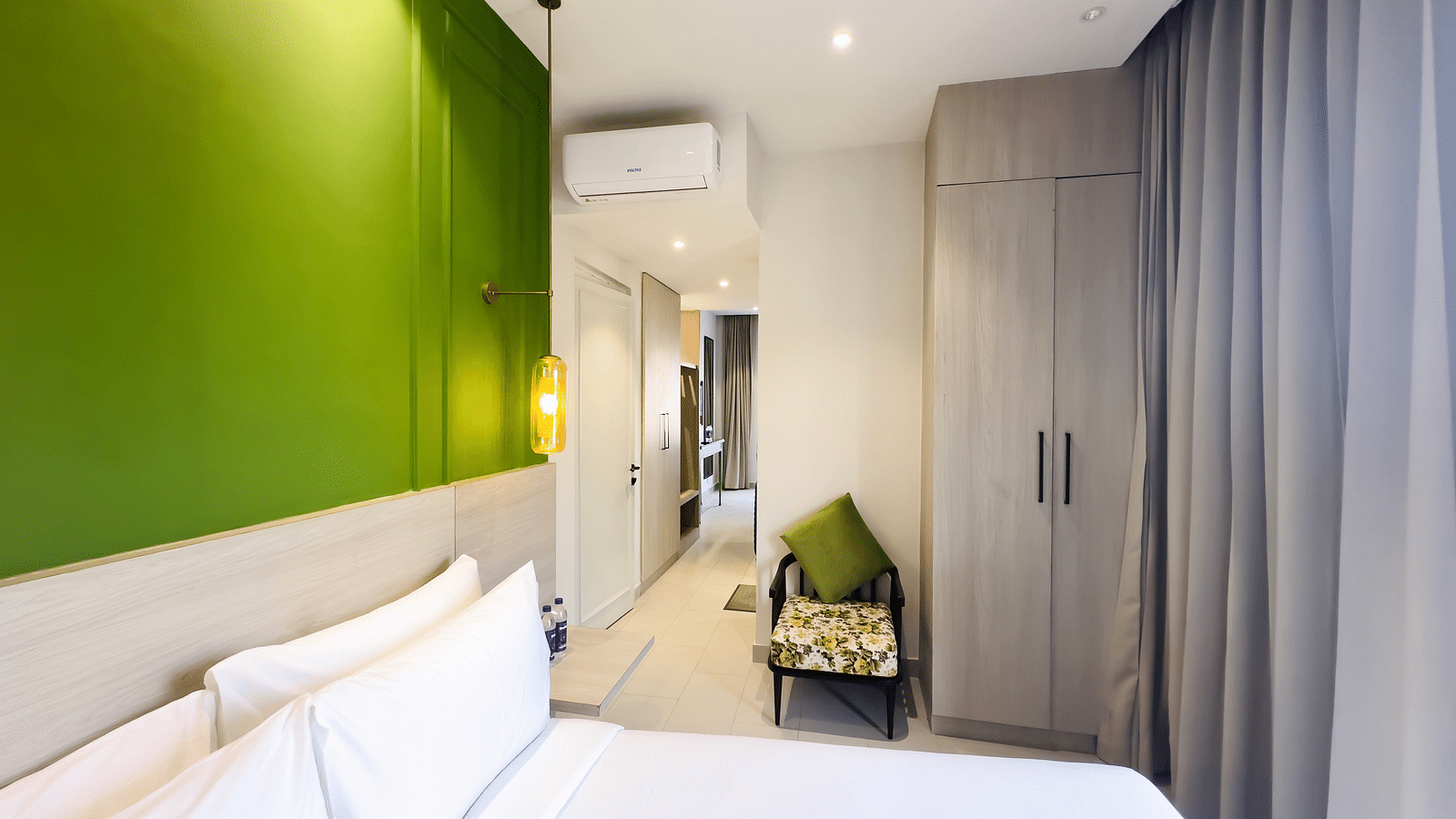 A hotel room with a large bed, a comfortable chair and a cupboard - Wonder Hills