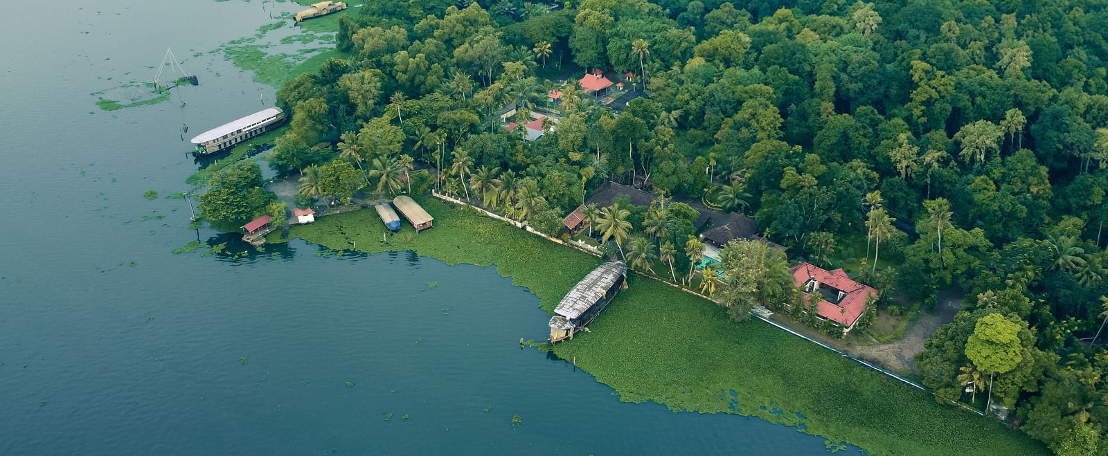 An aerial shot showcasing the Vembanad Lake and the resort surrounded by lush greenery - BluSalzz Villas - Muhamma Resort, Alleppey