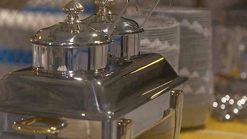 Close-up of a chafing dish and a tablecloth, slightly blurry.