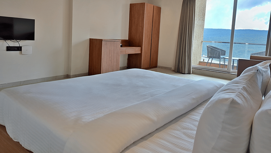 Bedroom with a double bed, wooden furnishings, and a scenic outdoor view