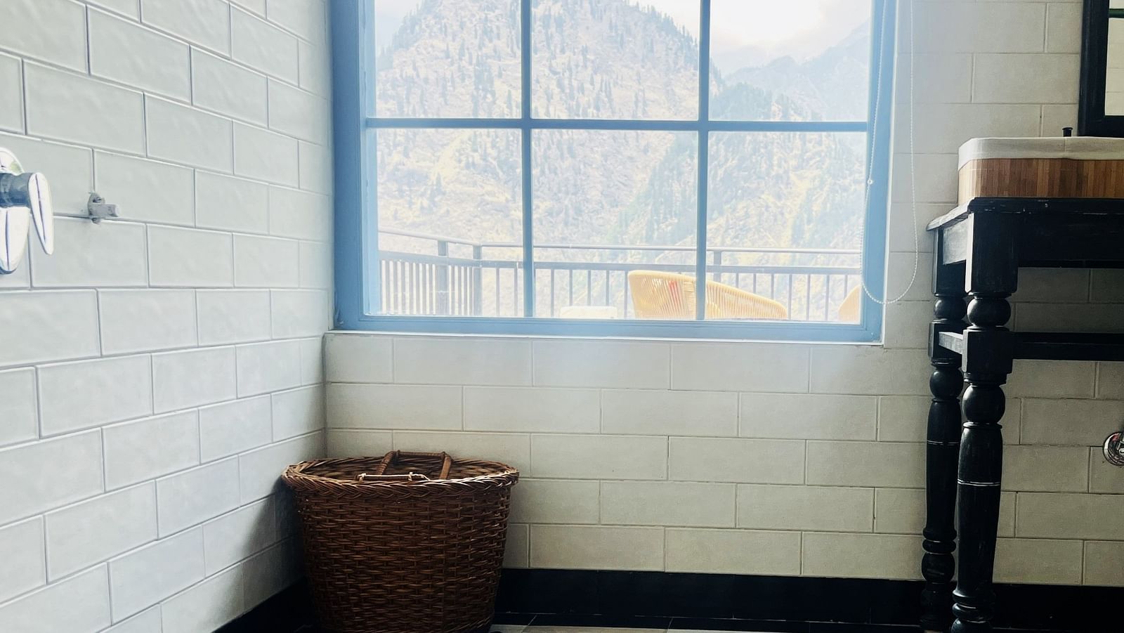 Minimalist bathroom with checkered floor and mountain view window | Faraway Cottages, Auli