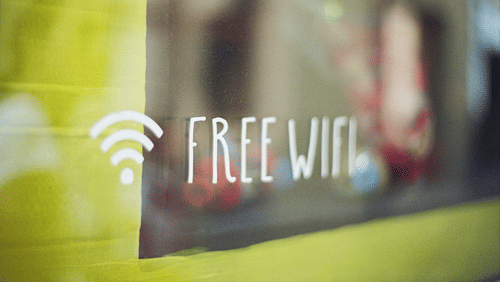 'Free Wi-Fi' written on a glass surface, with the networking logo beside.