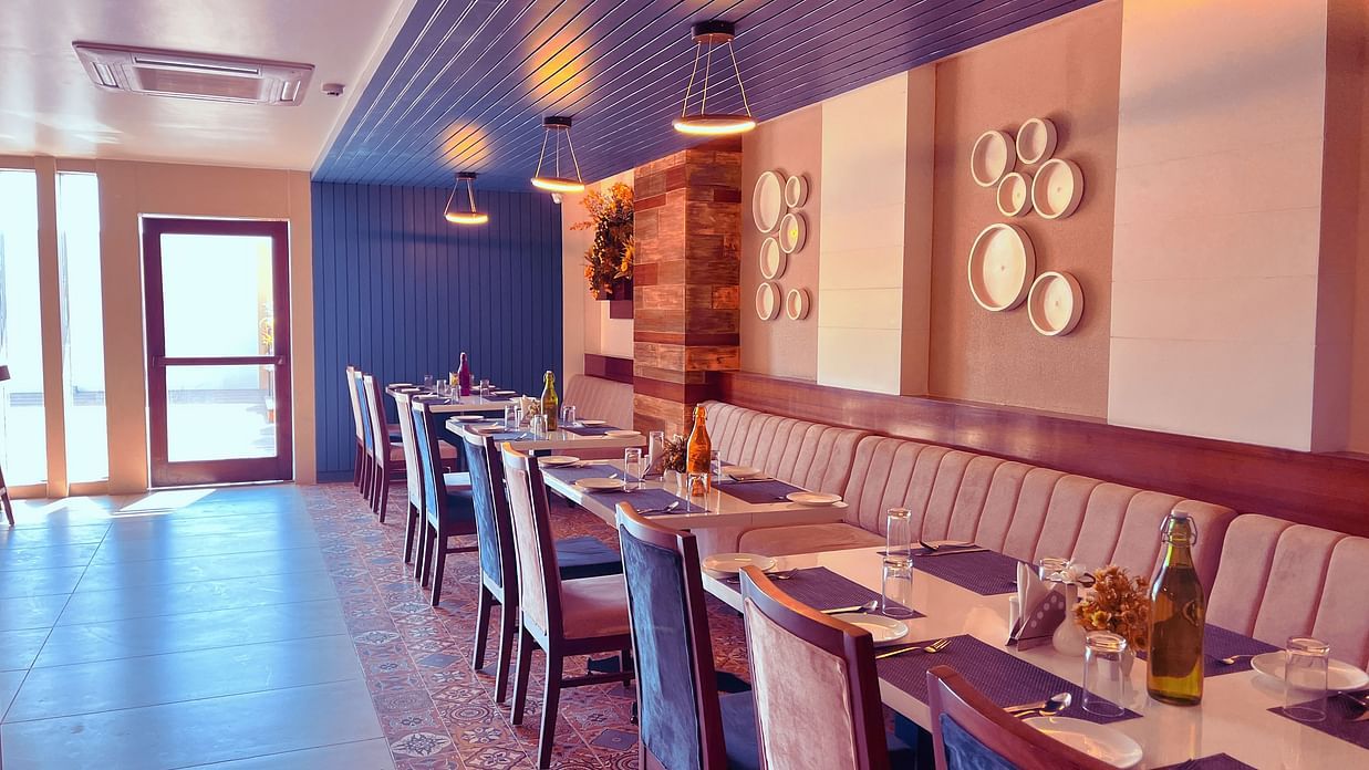 Image of a dining space with tables and chairs and lights on the ceiling at Clarks Inn Express, Udaipur