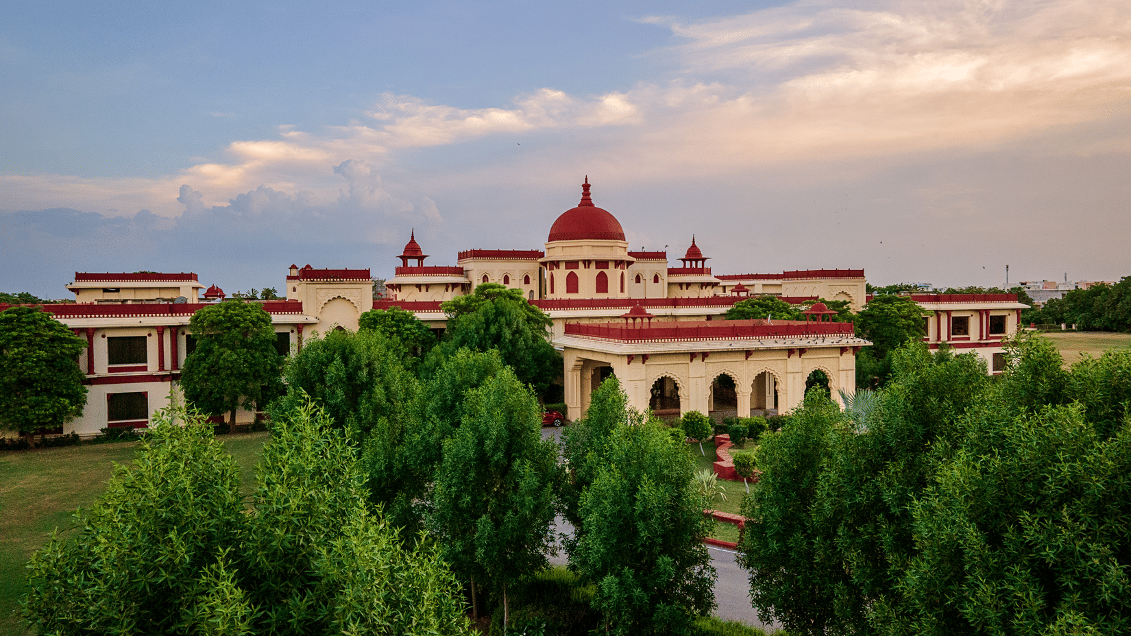 Luxury exterior view of The Ummed Jodhpur Palace Resort and Spa surrounded by lush greenery and heritage-inspired architecture
