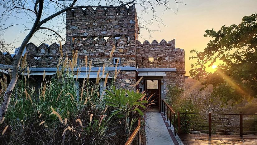 facade view of the Villa with a pathway leading to it and the sun setting in the background - Chunda Shikar Oudi.