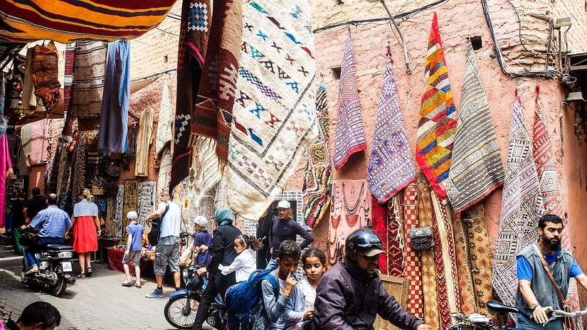 a street market with people moving on the road and different things being sold by vendors