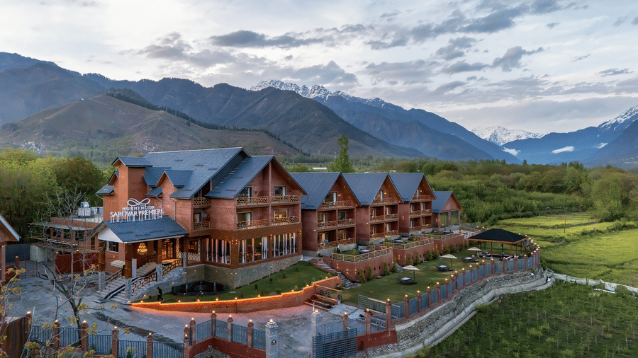 Aerial view of Mountnoor Sarovar Premiere, Pahalgam set amidst picturesque valleys and rolling hills.