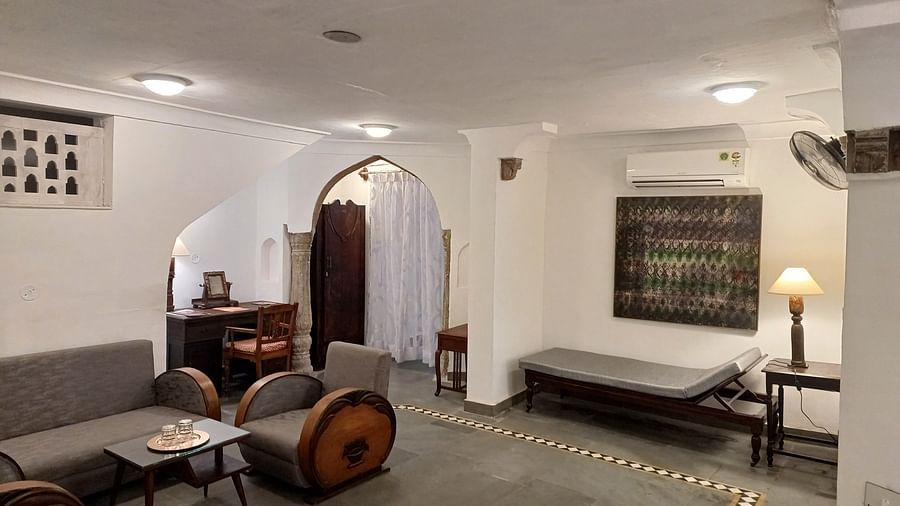 Lounge with leather armchairs, wooden coffee table, and arched stone doorway at Neemrana Fort-Palace.