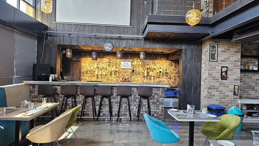side view of the seating arrangements and a bar counter at Bigg Shots Resto Bar in Quality Inn Rockwell Grand