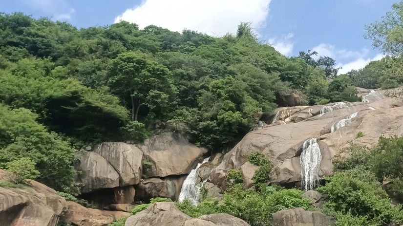 A small waterfall from the boulders with trees covering the area in Yelagiri, a perfect Getaway Places Near Chennai