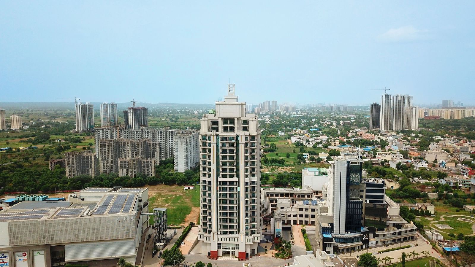 Bird's eye view of Rhythm Gurugram with other buildings and trees next to it 
