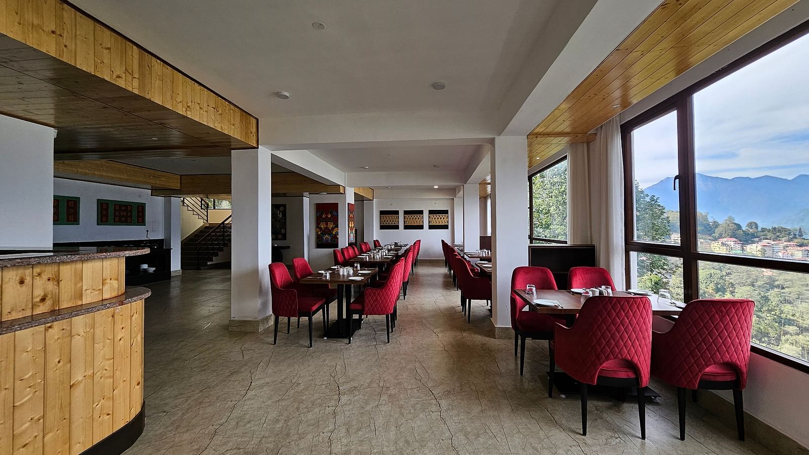 dining setting of a restaurant with red chairs at Sumitel Pelling, Geyzing