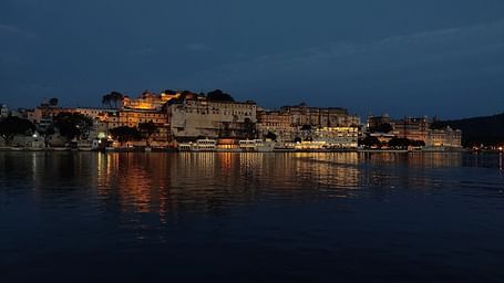 Night view of an old and royal fort amidst a lake.