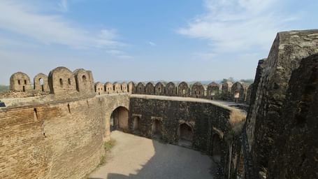 Outer stone walls and bastions of a historic fort with open courtyards.
