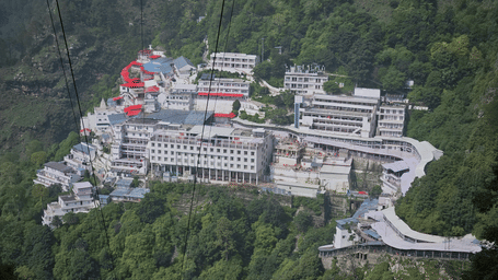 Aerial view of the Vaishno Devi Bhawan complex amidst dense forested hills, highlighting the sacred shrine's impressive mountain setting and scale