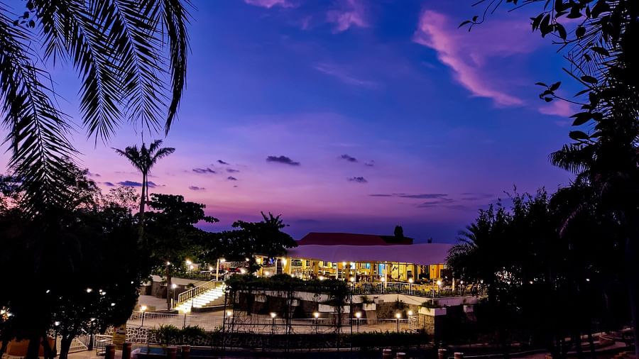 An evening view of the cafe which shows the blue sky and palm trees at the background | Diamond Parks, Pune