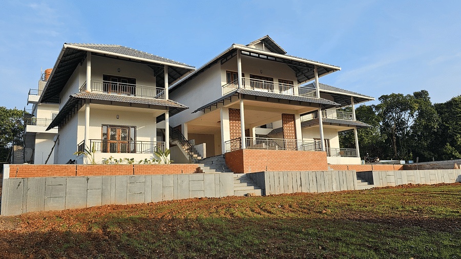 Modern homestay building set against beautiful hill views and open landscapes.