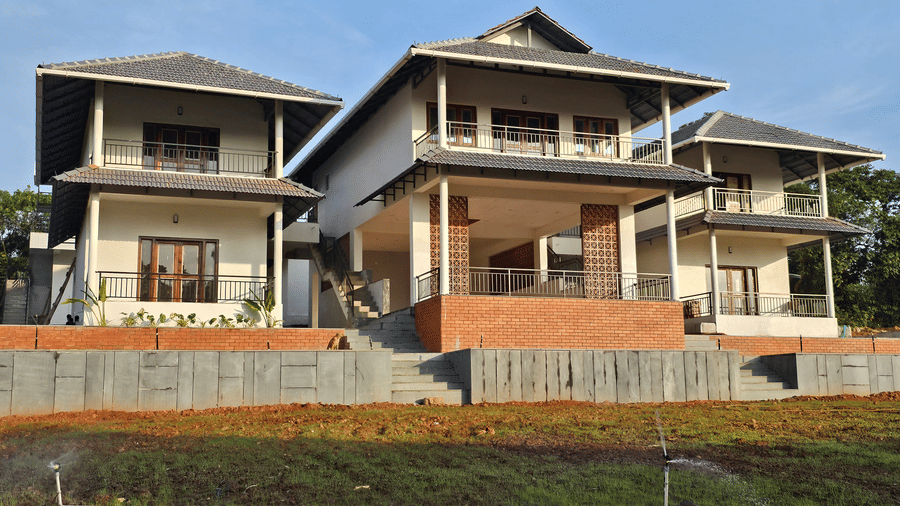 facade view of a hillock vista homestay surrounded by lush greenery.