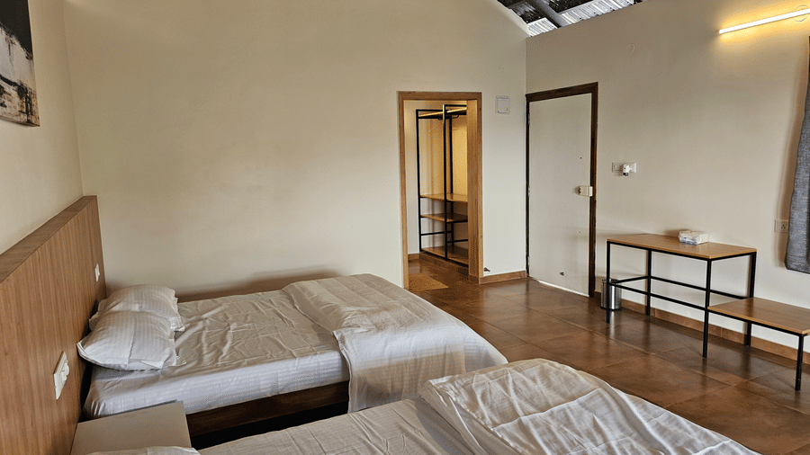 Spacious bedroom featuring multiple beds, a seating area, and contemporary décor.